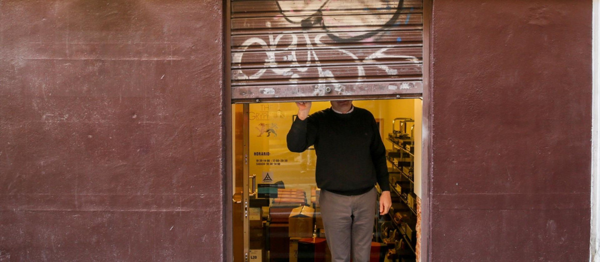 Un autónomo echa el cierre de su negocio tras su jornada laboral.