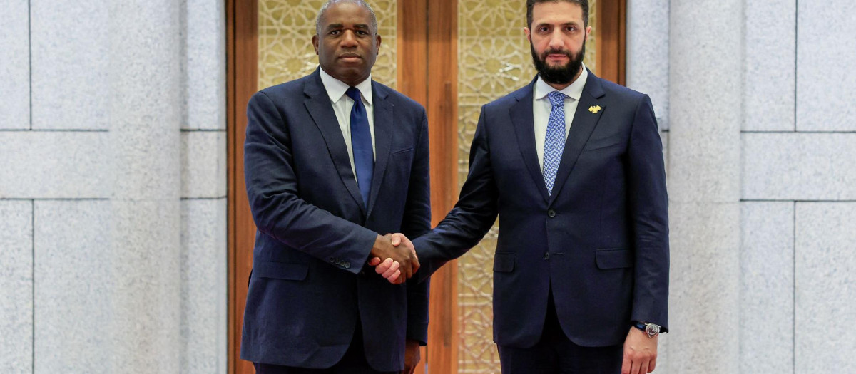 El presidente interino de Siria, Ahmad Al-Sharaa (der.), saludando al secretario de Relaciones Exteriores británico, David Lammy, en Damasco