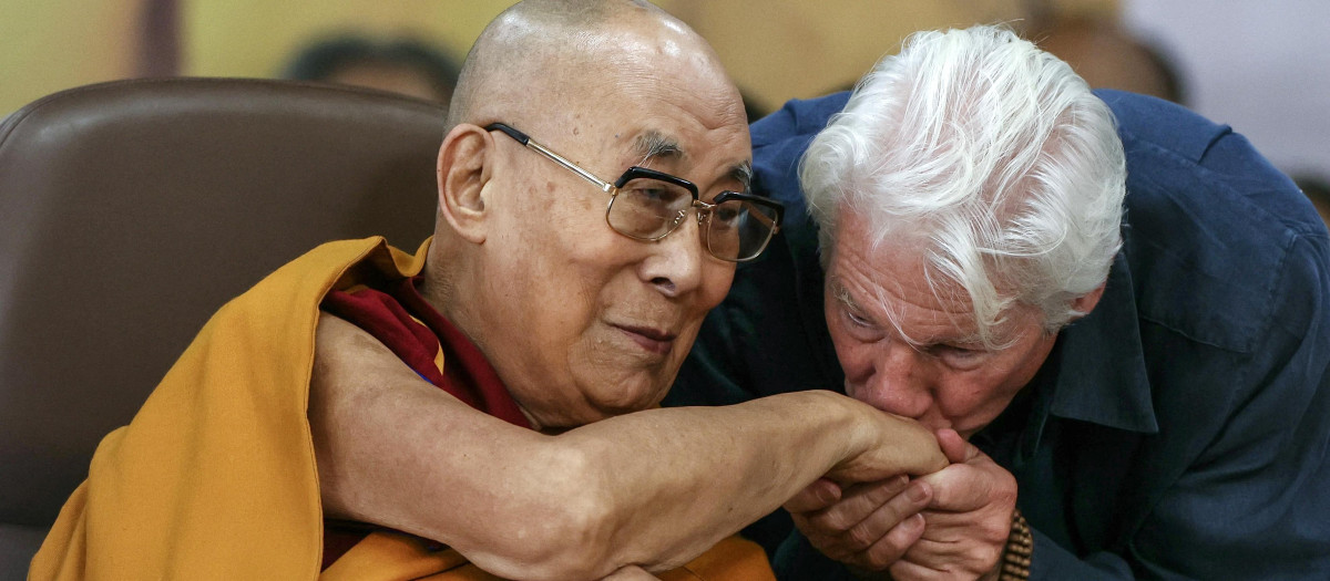 US actor Richard Gere (R) kisses Tibetan spiritual leader the Dalai Lama's hand during a prayer ceremony celebrating his 90th birthday at the Main Tibetan Temple in McLeod Ganj, near Dharamsala, on July 6, 2025. Calling himself a "simple Buddhist monk" who usually didn't celebrate birthdays, the Dalai Lama marked his 90th on July 6 by praying for peace after China insisted it would have the final say on who succeeded the Tibetan spiritual leader. (Photo by Niharika KULKARNI / AFP)