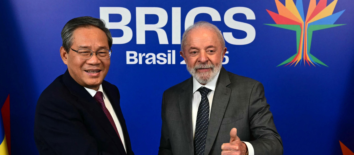 El presidente de Brasil, Luiz Inácio Lula da Silva (der.), saluda con el pulgar al estrechar la mano del primer ministro chino, Li Qiang,