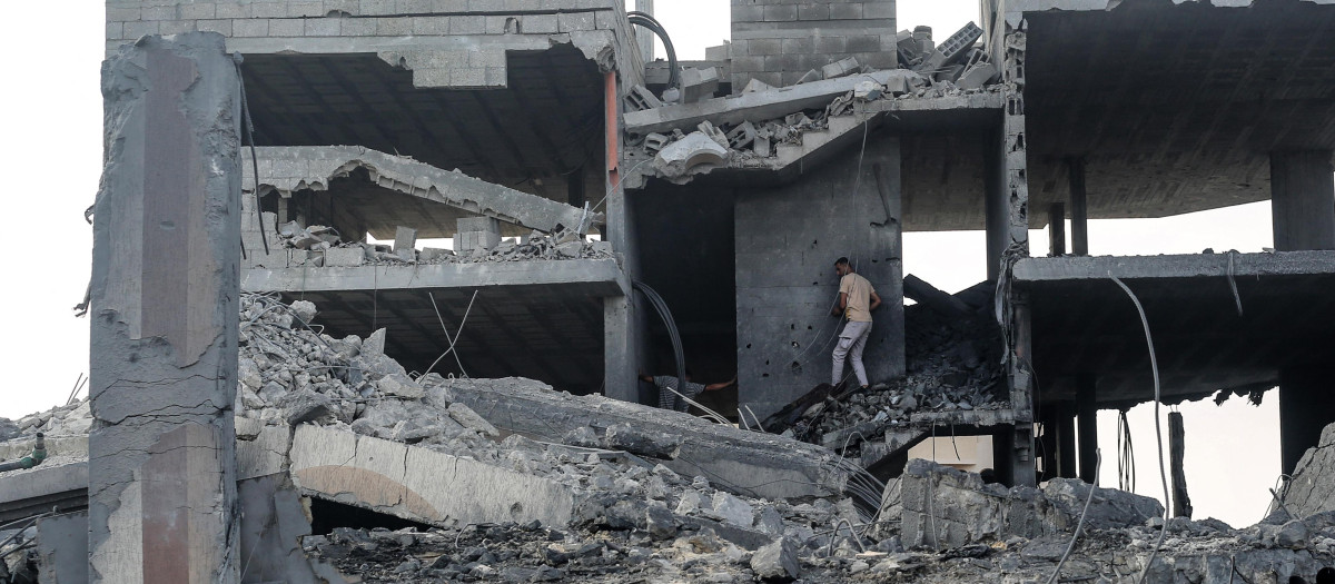 Un hombre palestino se abre paso entre los escombros de un edificio alcanzado por un ataque israelí en el campo de refugiados de Bureij, en el centro de la Franja de Gaza,