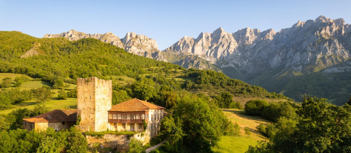 El pueblo con su torre medieval y los Picos de Europa al fondo.