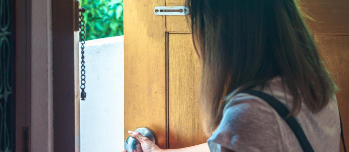 Una mujer atraviesa una puerta de su casa