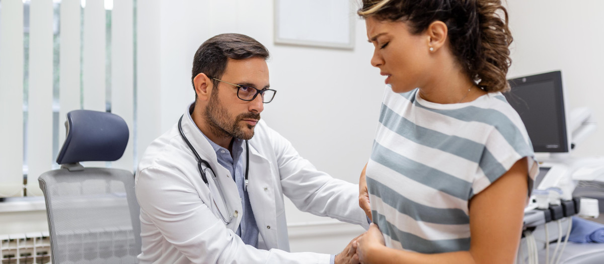 Un doctor que atiende a una paciente que padece cáncer de hígado
