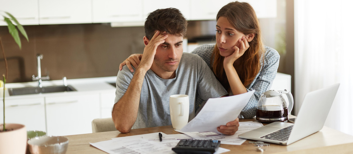 pareja joven comprobando su presupuesto familiar