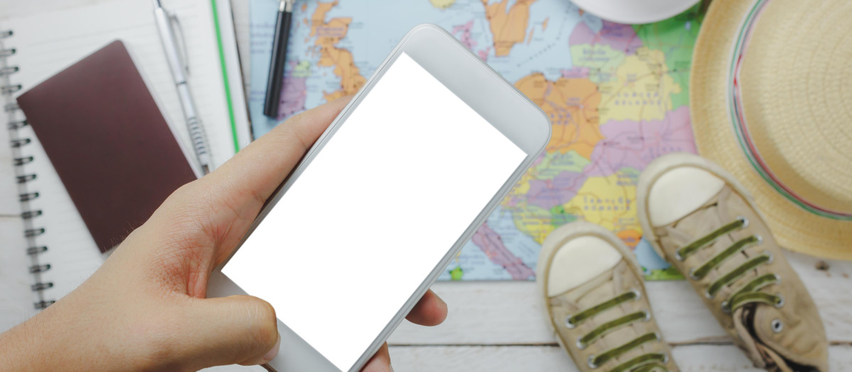 Top view / Flat lay hand using mobile phone on blur accessories to travel.