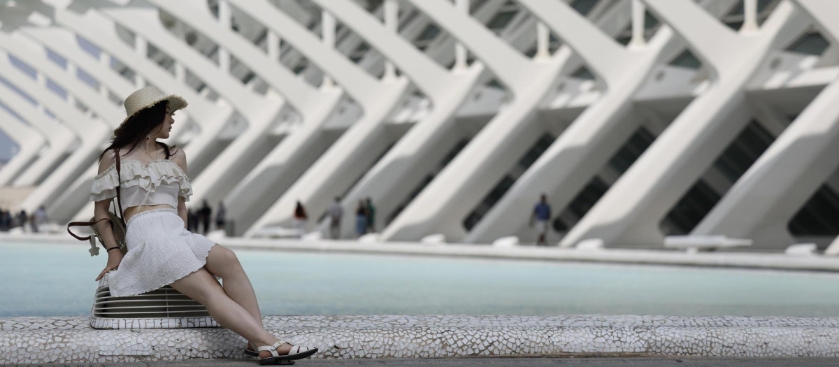 Imagen de archivo de una turista con sombrero junto al lago de la Ciudad de las Artes y las Ciencias de Valencia
