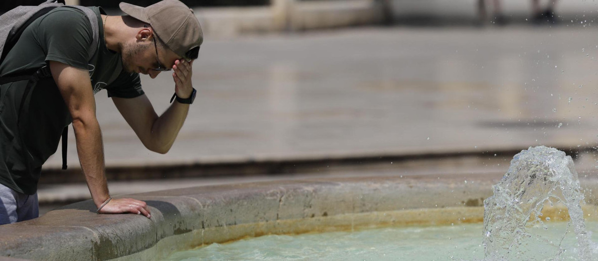 Imagen tomada este martes de un turista refrescándose en una fuente de Valencia