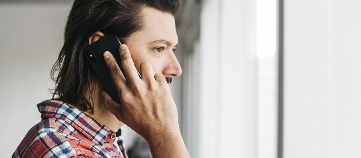 vista lateral de un joven hablando por telefono movil