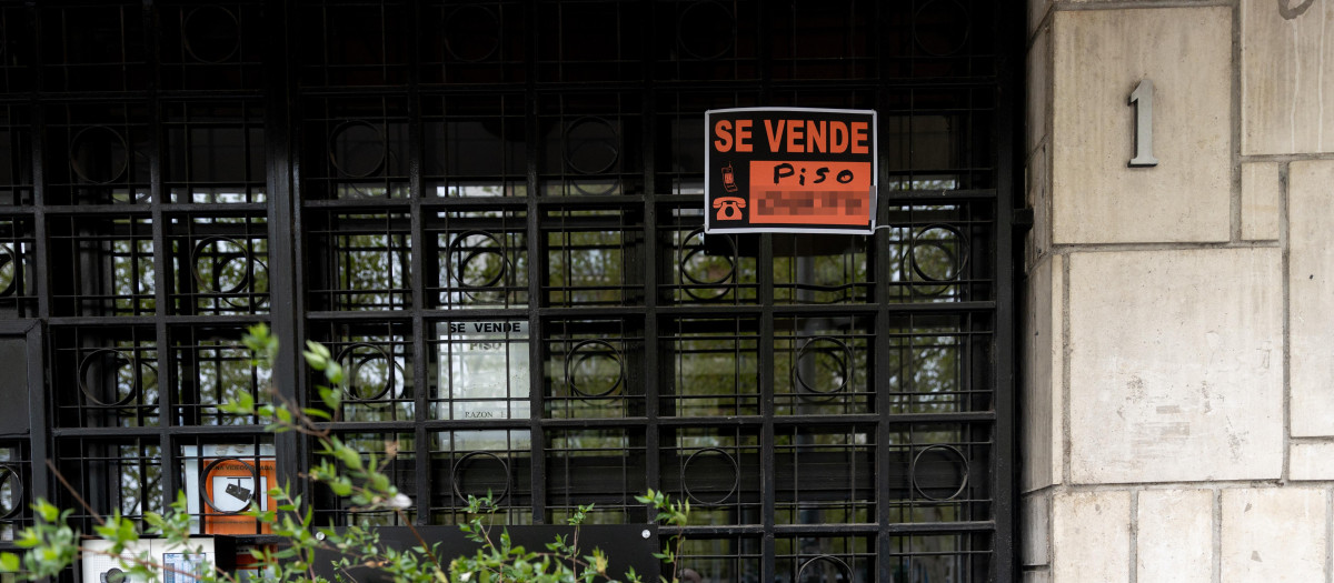 Vista de un cartel de 'Se vende' en un portal de un edificio