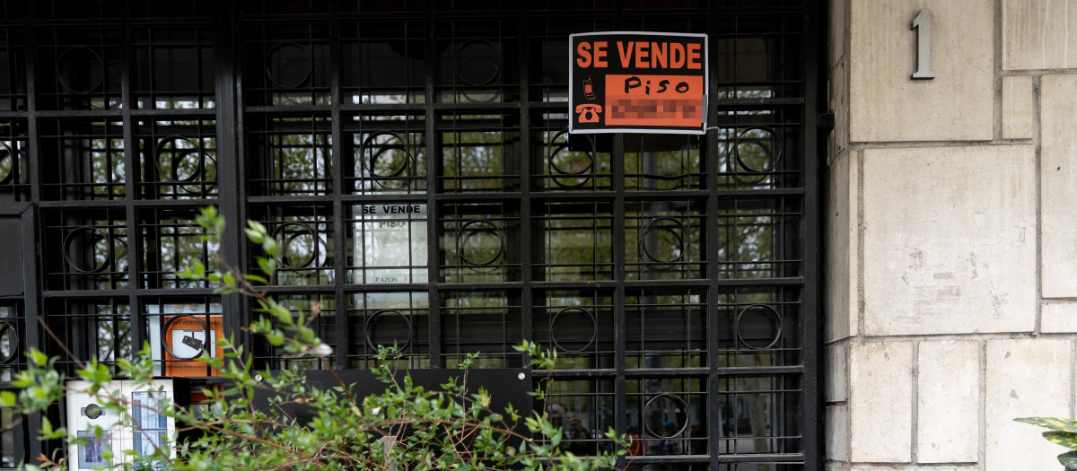 Vista de un cartel de 'Se vende' en un portal de un edificio