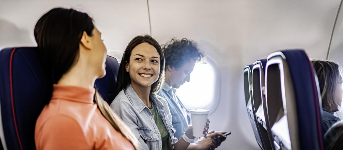 Pasajeras charlando en un avión.