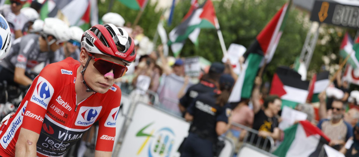 Vingegaard espera, delante de un grupo de manifestantes, el comienzo de una etapa de La Vuelta