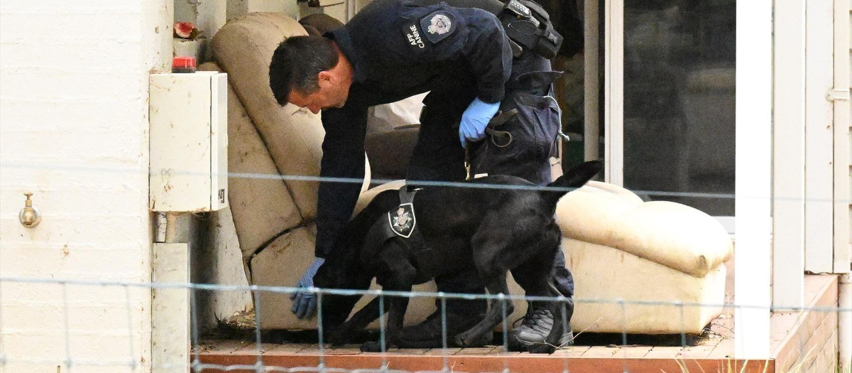 Un agente de policía y su perro son vistos en la propiedad de Erin Patterson en Leongatha, Victoria