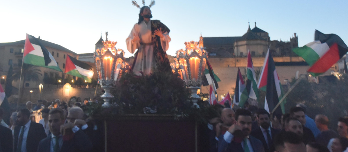 La Hermandad del Huerto en el Puente Romano, flanqueada por los manifestantes pro-Palestina
