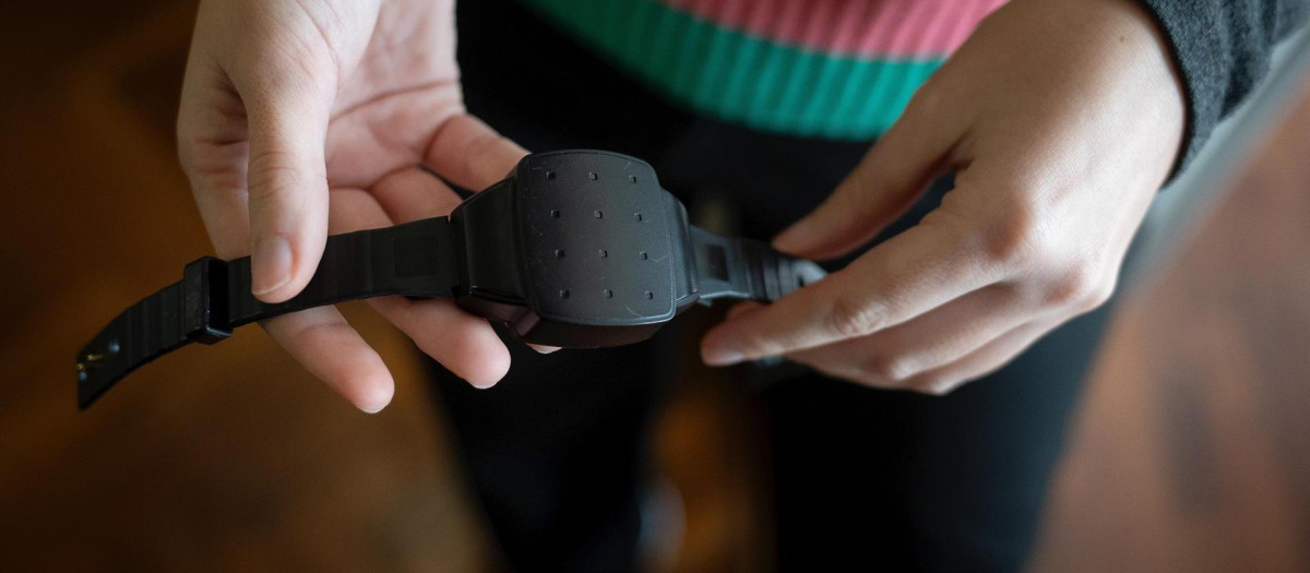Una persona muestra una pulsera electrónica de geolocalización (archivo)