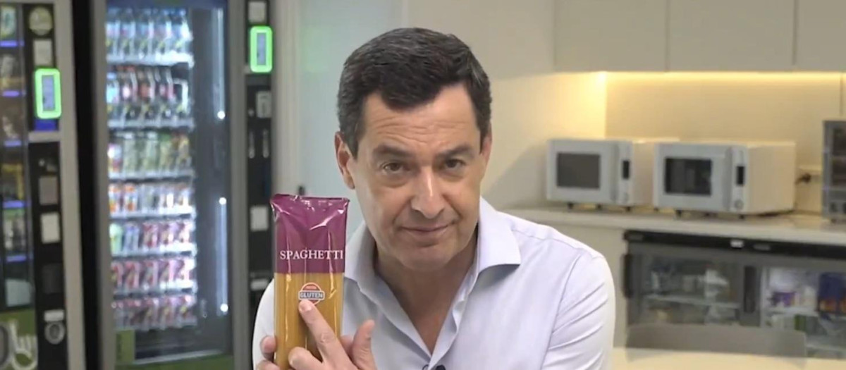 El presidente de la Junta de Andalucía, Juanma Moreno, sostiene un paquete de espaguetis sin gluten