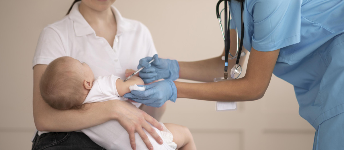 Una enfermera vacuna a un bebé