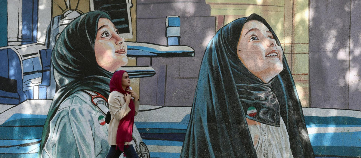 Una mujer iraní pasa junto a un mural en una calle de Teherán, Irán, el 20 de octubre de 2025