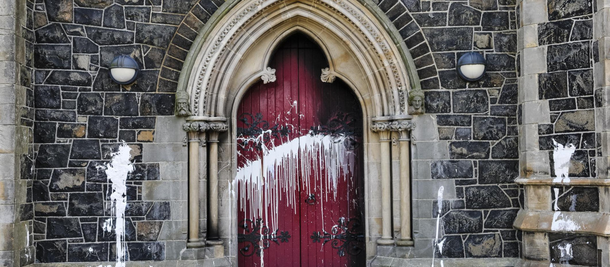 The door of a Roman Catholic Church suffers scorch damage from petrol bombs and paint during a sectarian attack