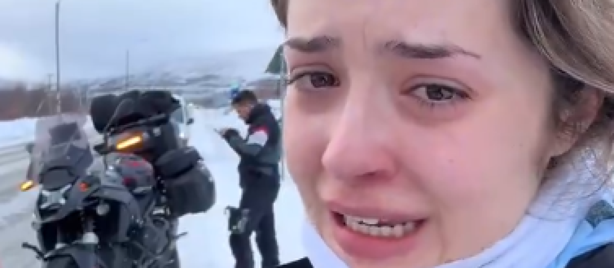 La joven junto a su acompañante y la motocicleta