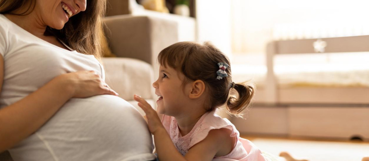 Una mamá embarazada y la hermana mayor del bebé