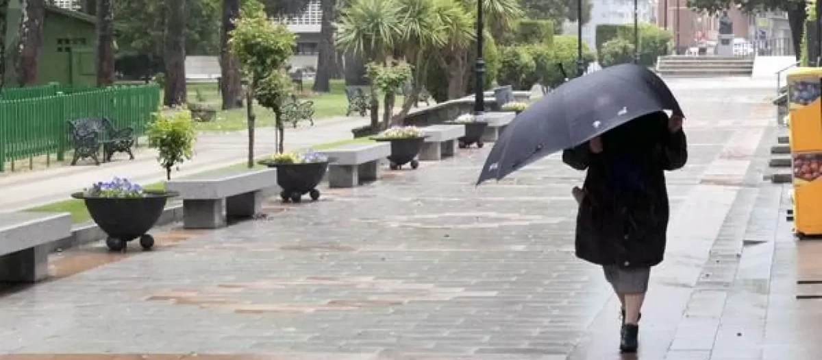 Mujer caminando con paraguas