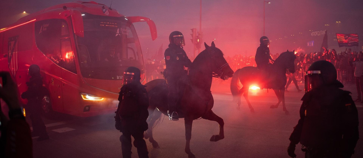 Varios agentes de la Policía Nacional a caballo escoltan el autobús del Atlético de Madrid