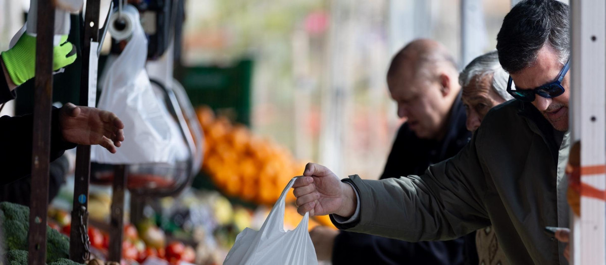 Varias personas compran en un mercado de alimentos.