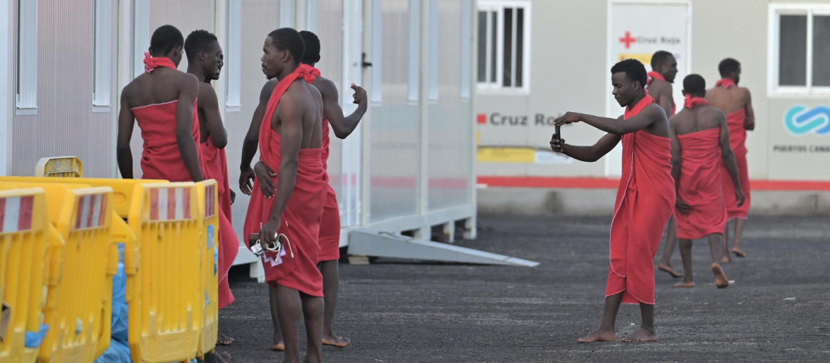Un inmigrante rescatado por Salvamento Marítimo toma una foto a un compañero en el puerto de La Restinga