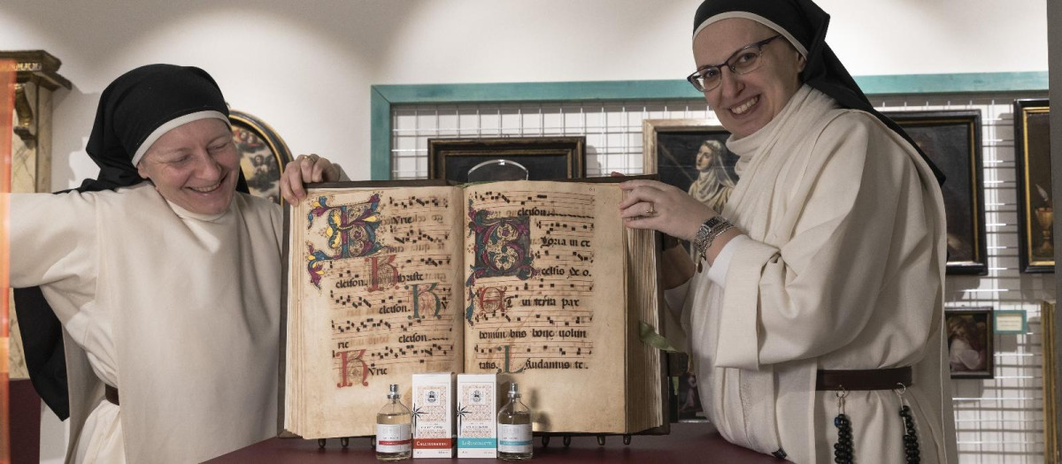 Dos religiosas del monasterio presentan algunos de sus productos delante de un libro de canto gregoriano