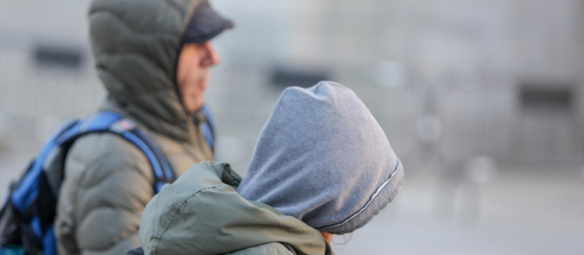 Imagen de archivo de dos personas resguardándose del frío