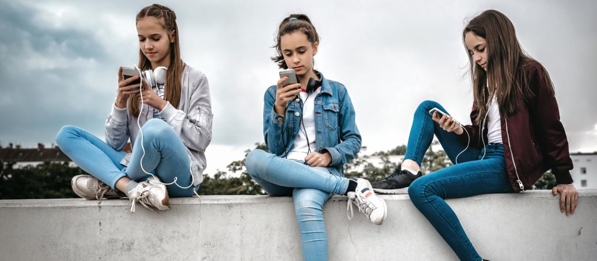 Tres adolescentes con su teléfono móvil