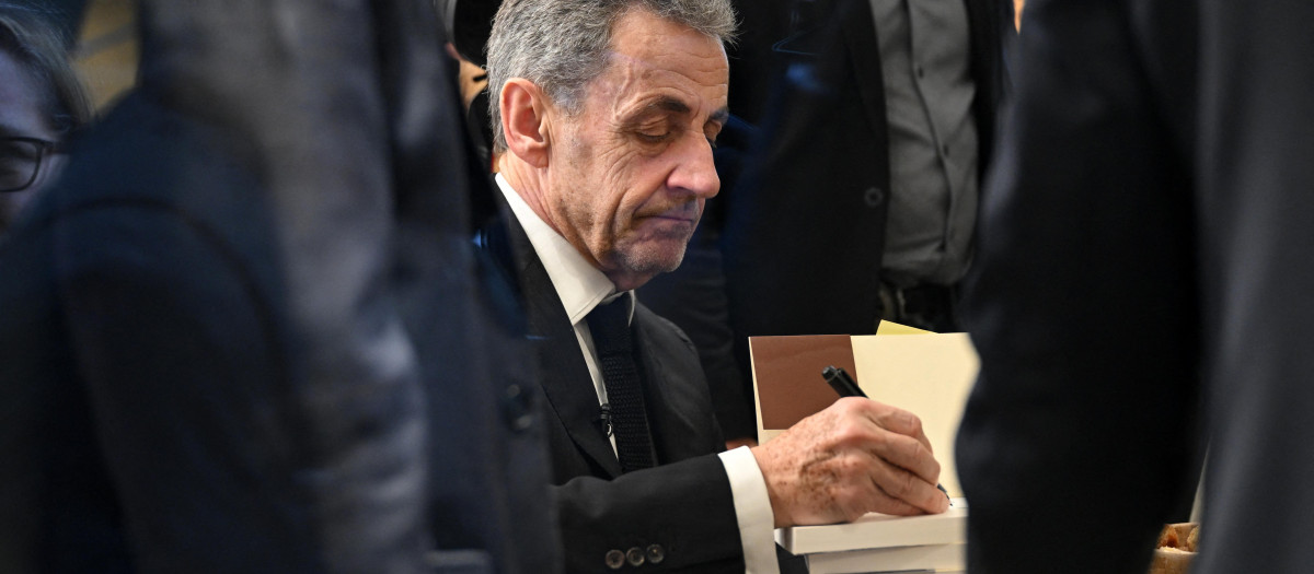 El expresidente francés, Nicolas Sarkozy, firmando uno de sus libros