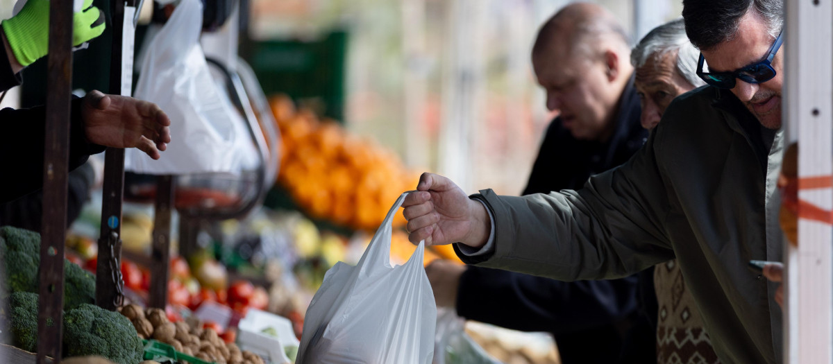 Varias personas compran en un mercado de alimentos