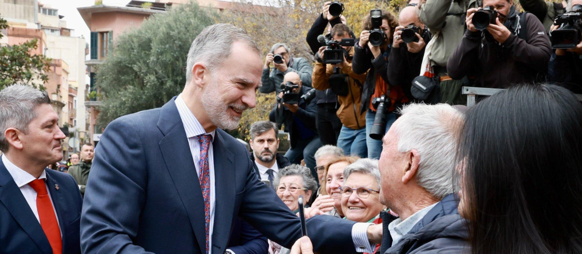 El Rey Felipe VI saluda a unos vecinos a su llegada a L'Hospitalet de Llobregat