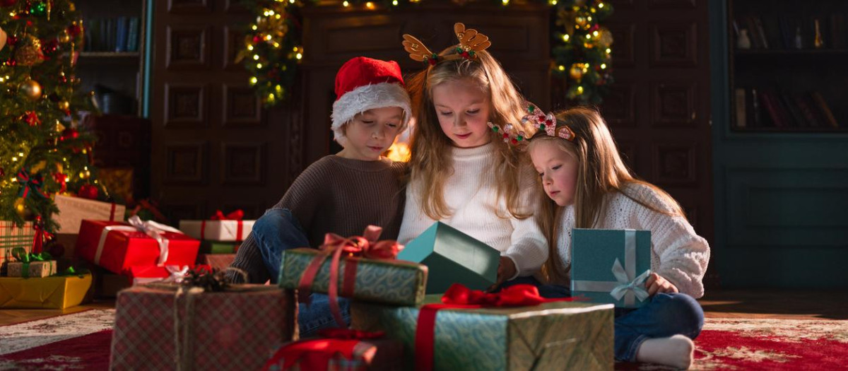 Unos niños abriendo sus regalos navideños