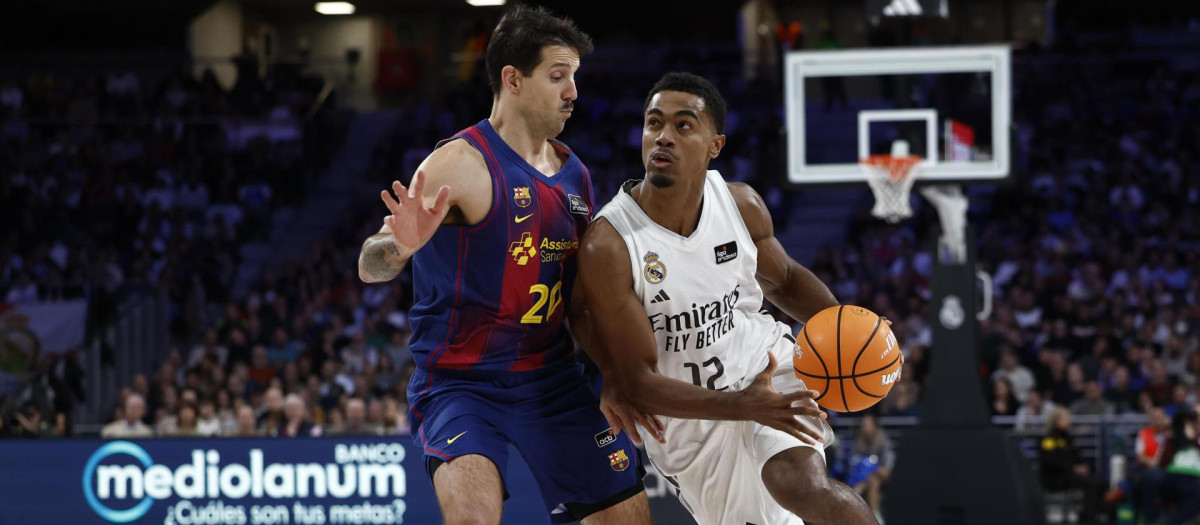 El base del Real Madrid Theo Louis Maledon (d) disputa un balón al base del FC Barcelona Nicolas Laprovittola (i) durante el partido de la ACB