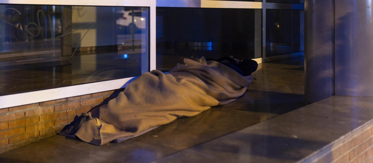 Una persona sin hogar duerme en una calle de Badalona, en una foto de archivo