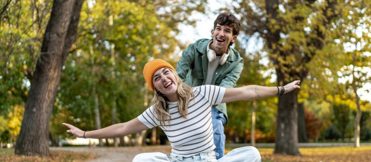 Una pareja de jóvenes adultos en patinete