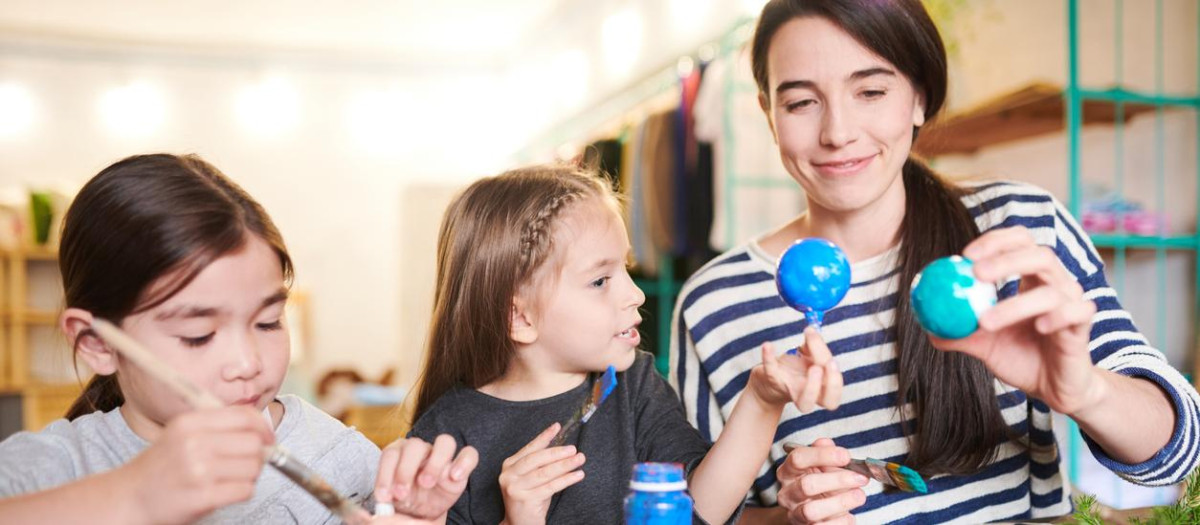 Una madre, junto a sus dos hijas, haciendo manualidades para el colegio