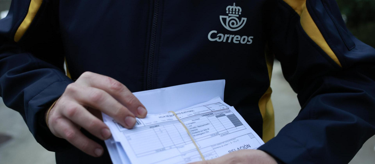 Un empleado de correos poco antes de entregar el voto por correo a una mesa electoral