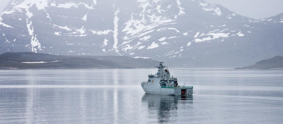 El buque patrullero de la Armada danesa HDMS Ejnar Mikkelsen rodeado de montañas cubiertas de nieve en la entrada de mar que conduce a Nuuk, Groenlandia