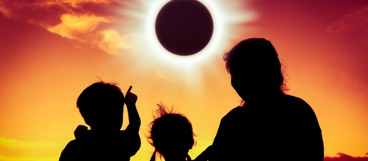 Imagen de archivo de una familia observando un eclipse