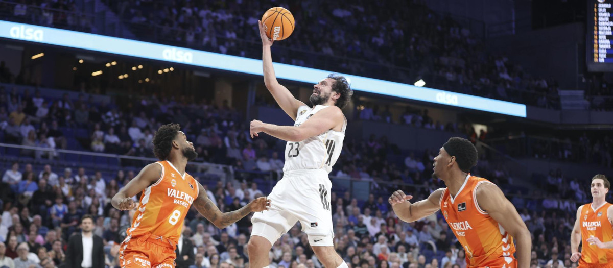 El jugador del Real Madrid Sergio Llull (c), y el jugador del Valencia J. Montero, durante el partido de la Liga Endesa