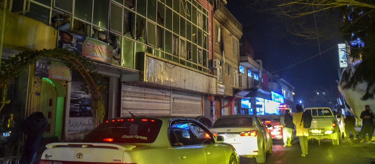 Automovilistas pasan junto a un edificio con vidrios rotos luego de una explosión en el área de Shahr-e Naw en Kabul