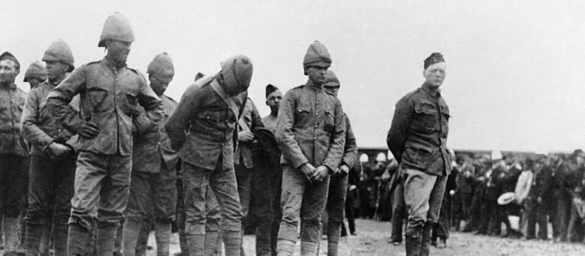 Churchill (primero por la derecha) se muestra desafiante a su llegada al campo de prisioneros de Pretoria tras ser capturado por los bóers