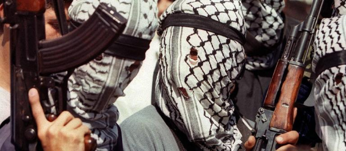 Miembros de Hamás con el rostro cubierto empuñando sus kalashnikov
