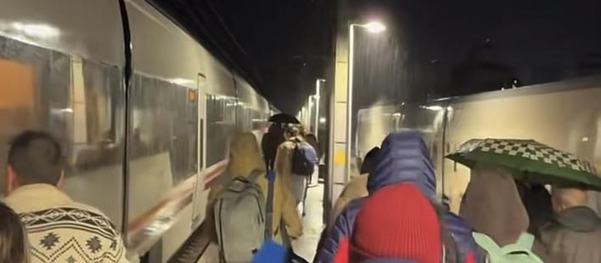 Imagen de los pasajeros del Alvia mientras cambiaban de un tren a otro bajo la lluvia
