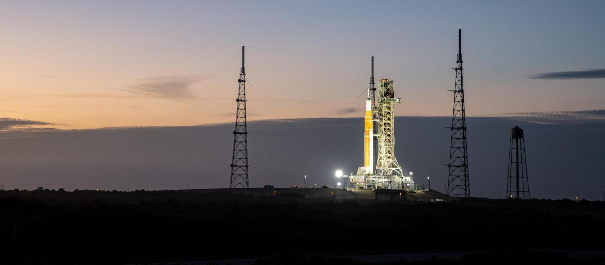 El cohete del Sistema de Lanzamiento Espacial Artemisa II (SLS) de la NASA y la nave espacial Orión se ven iluminados por luces en el Complejo de Lanzamiento 39B